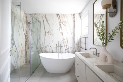 Baño moderno con bañera exenta y pared de mármol llamativa — proyecto Lacroze, por Estudio Losa, en Belgrano